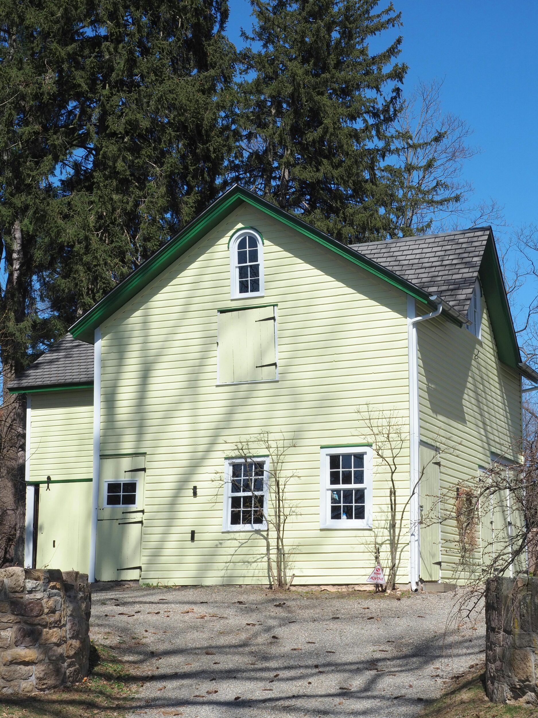 Yellow farmhouse under clear blue sky in Doylestown, PA countryside. Perfect rural escape.